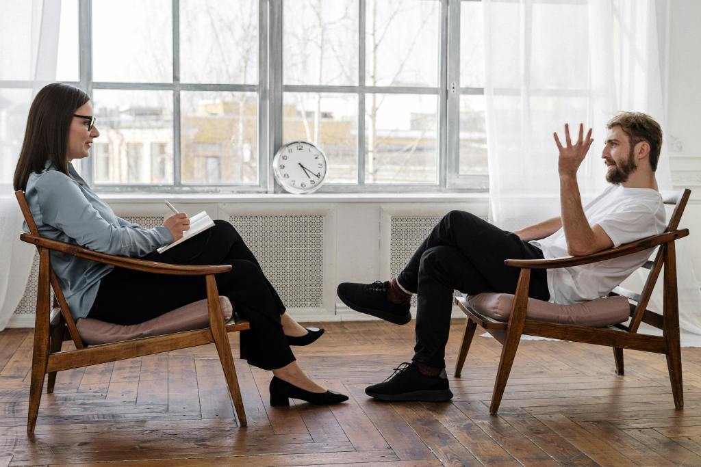 Man and woman talking in a therapy setting.